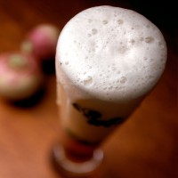 Beer with a beautiful head of foam and turnips